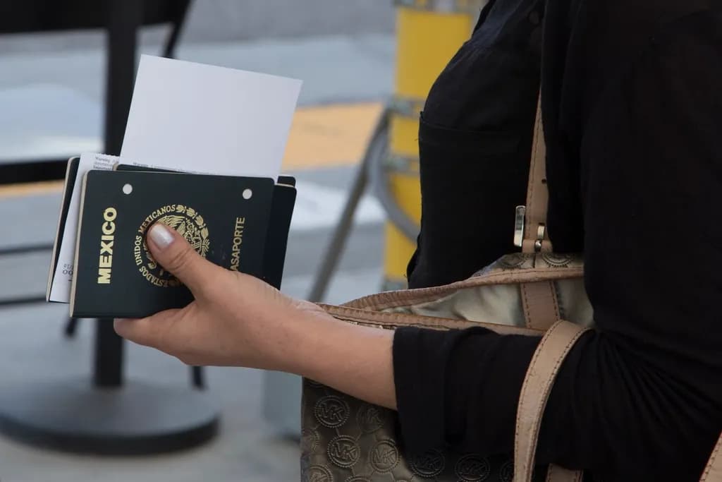 O persoană ține în mână un pașaport mexican și un document, într-un context de control la frontieră sau aeroport. (Foto ilustrativă: necunoscut / CC0 1.0, Openverse)