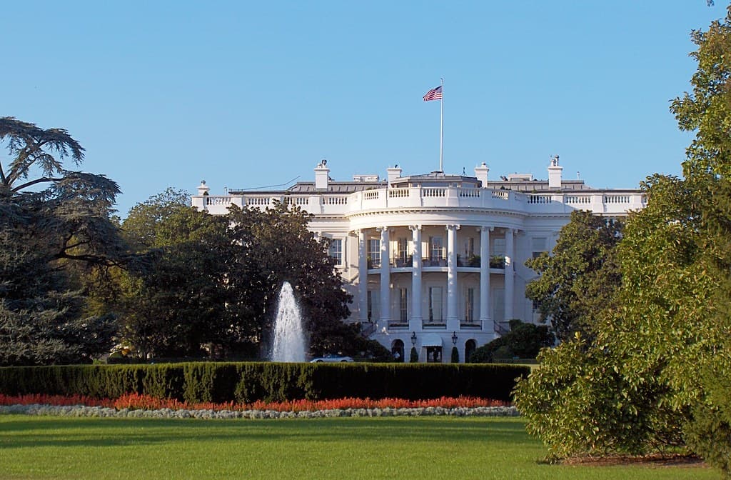 Casa Albă din Washington, cu steagul SUA, văzută din grădină. (Foto: foxypar4 / BY 2.0, Openverse)