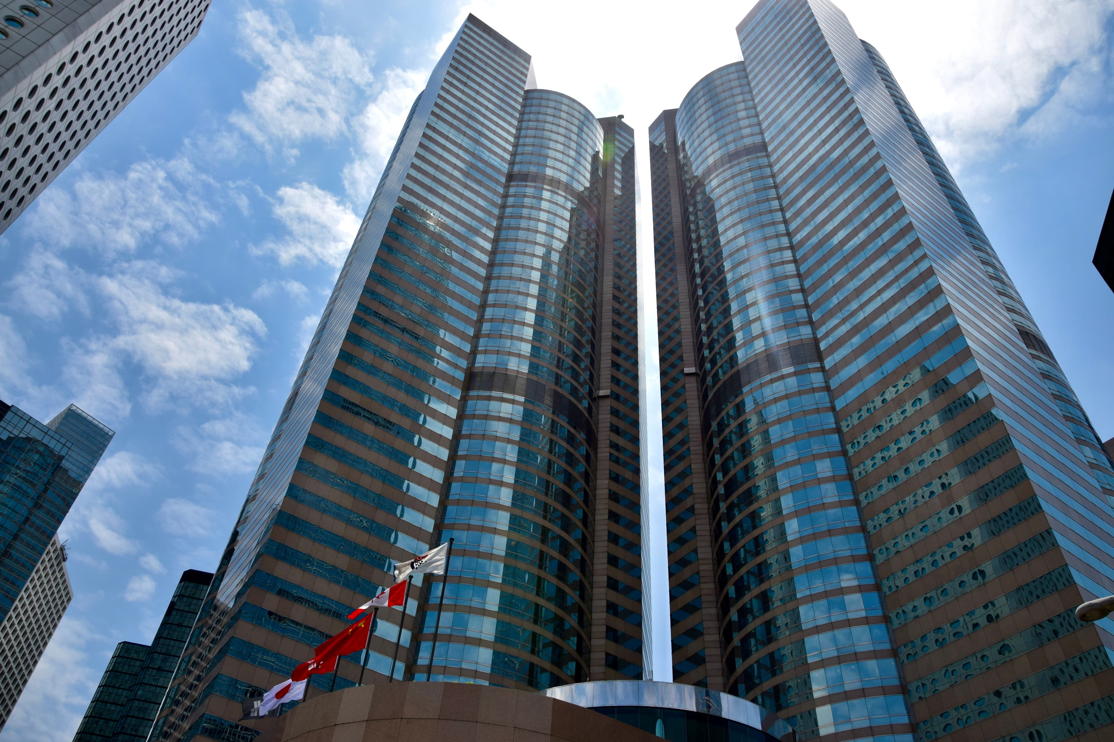 Clădiri moderne de birouri, cu steaguri chinezești în față, probabil sediul unei companii din China. (Foto: Ank Kumar / BY-SA 4.0, Openverse)