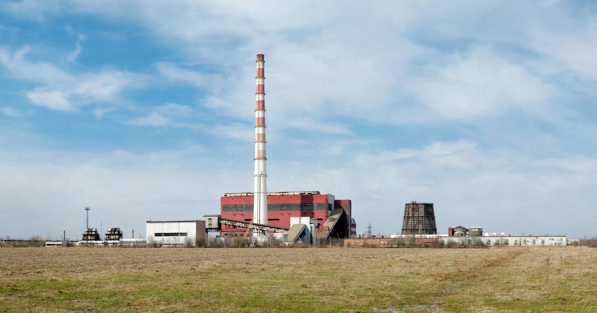 O centrală sau un complex energetic industrial, cu o clădire mare și un coș de fum înalt, fotografiat de la distanță. (Foto: Andy Shustykevych / CC BY-SA 3.0, Wikimedia Commons)