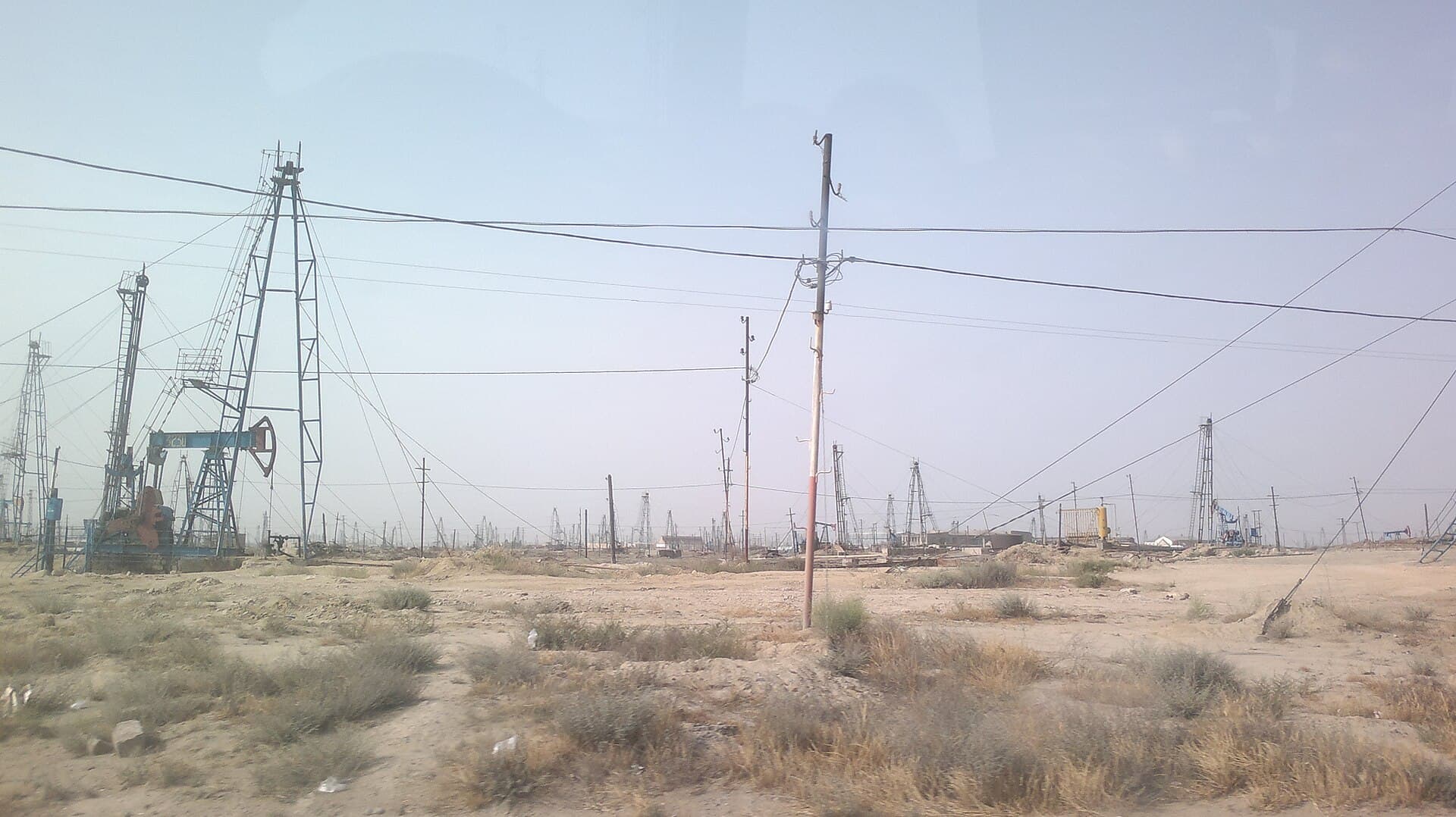 Un peisaj arid cu instalații de extracție a petrolului, sonde și infrastructură energetică. (Foto de arhivă: Interfase / CC BY-SA 3.0, Wikimedia Commons)