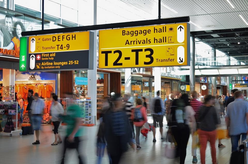 Interiorul unui aeroport aglomerat, cu indicatoare către zona de sosiri și transferuri. (Foto ilustrativă: Skitter Photo / CC0 1.0, Openverse)
