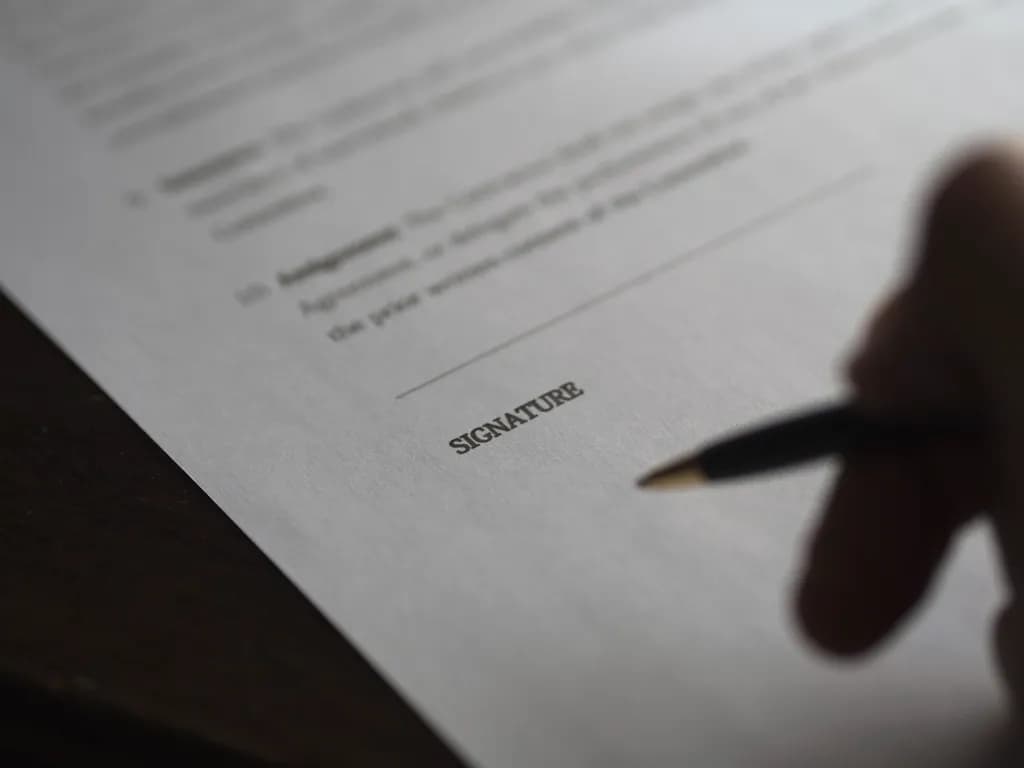 Un document contractual pe care o persoană îl semnează cu un pix. (Foto ilustrativă: necunoscut / CC0 1.0, Openverse)