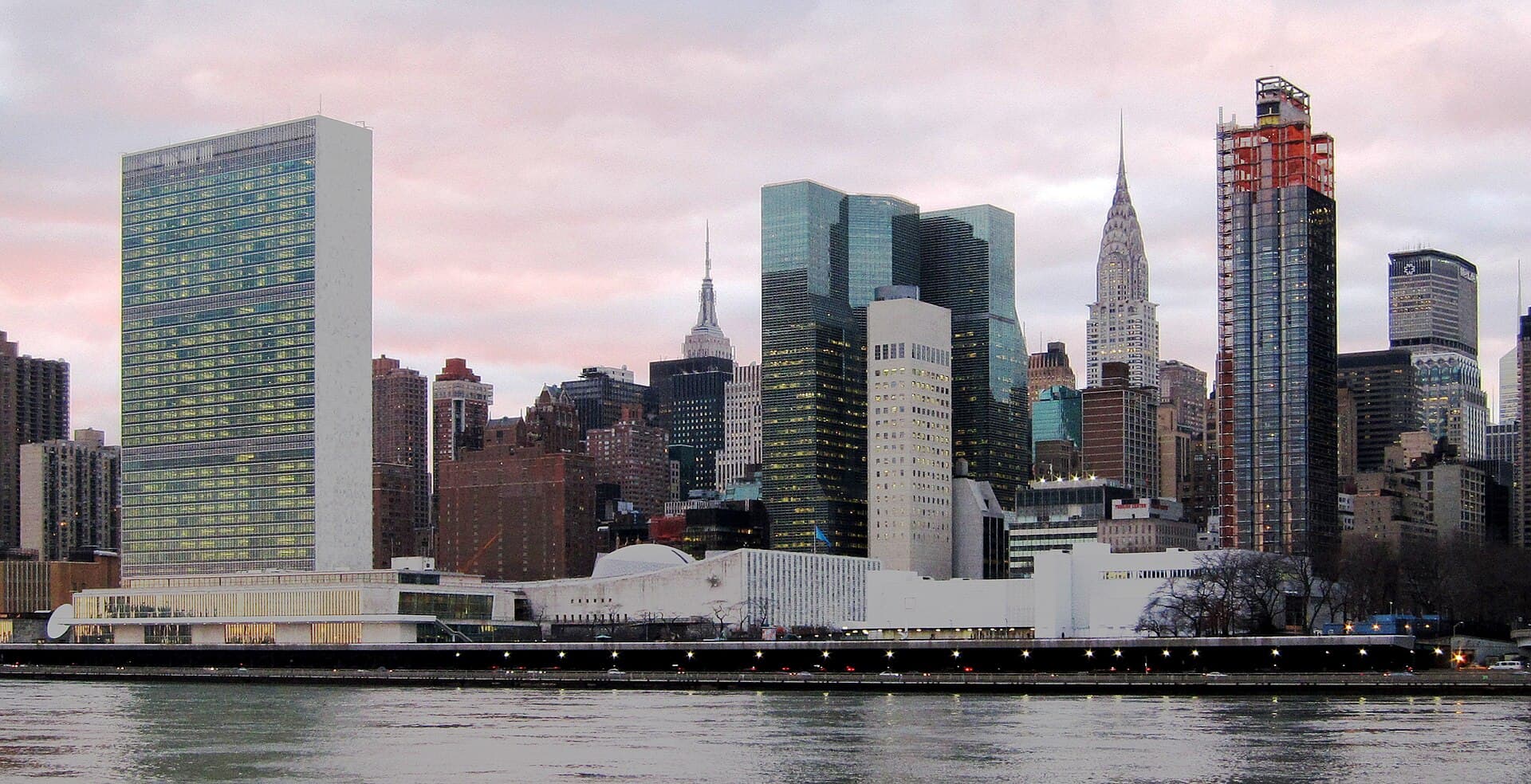 Panoramă a orașului New York, cu clădiri și râul în prim-plan. (Foto: Neptuul / CC BY-SA 3.0, Wikimedia Commons)