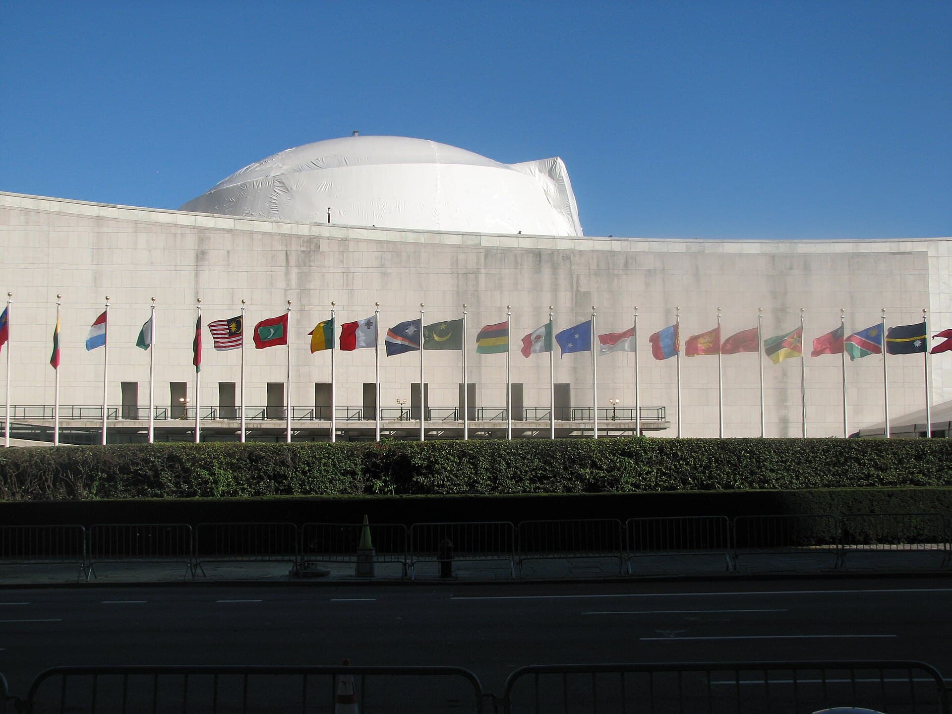Clădirea sediului ONU, cu șirul de steaguri ale statelor membre în fața sa. (Foto: USAID U.S. Agency for International Development / Public domain, Wikimedia Commons)