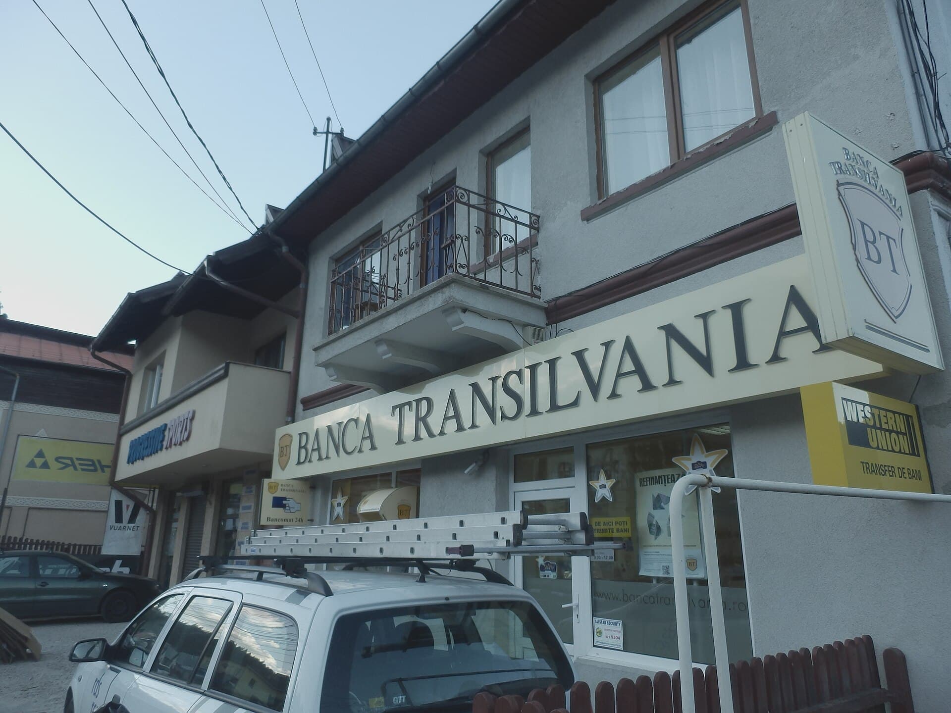 Se vede exteriorul unei sucursale Banca Transilvania, cu firma băncii vizibilă pe clădire. (Foto: Stefan Jurca from Munich, Germany / CC BY-SA 2.0, Wikimedia Commons)
