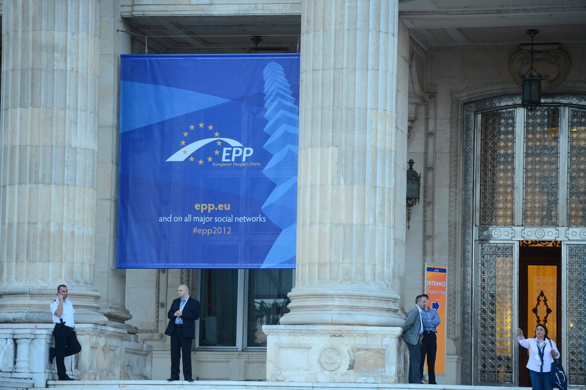 Exteriorul unei clădiri a Parlamentului, cu un banner al Partidului Popular European între coloane. (Foto: European People's Party / CC BY 2.0, Wikimedia Commons)