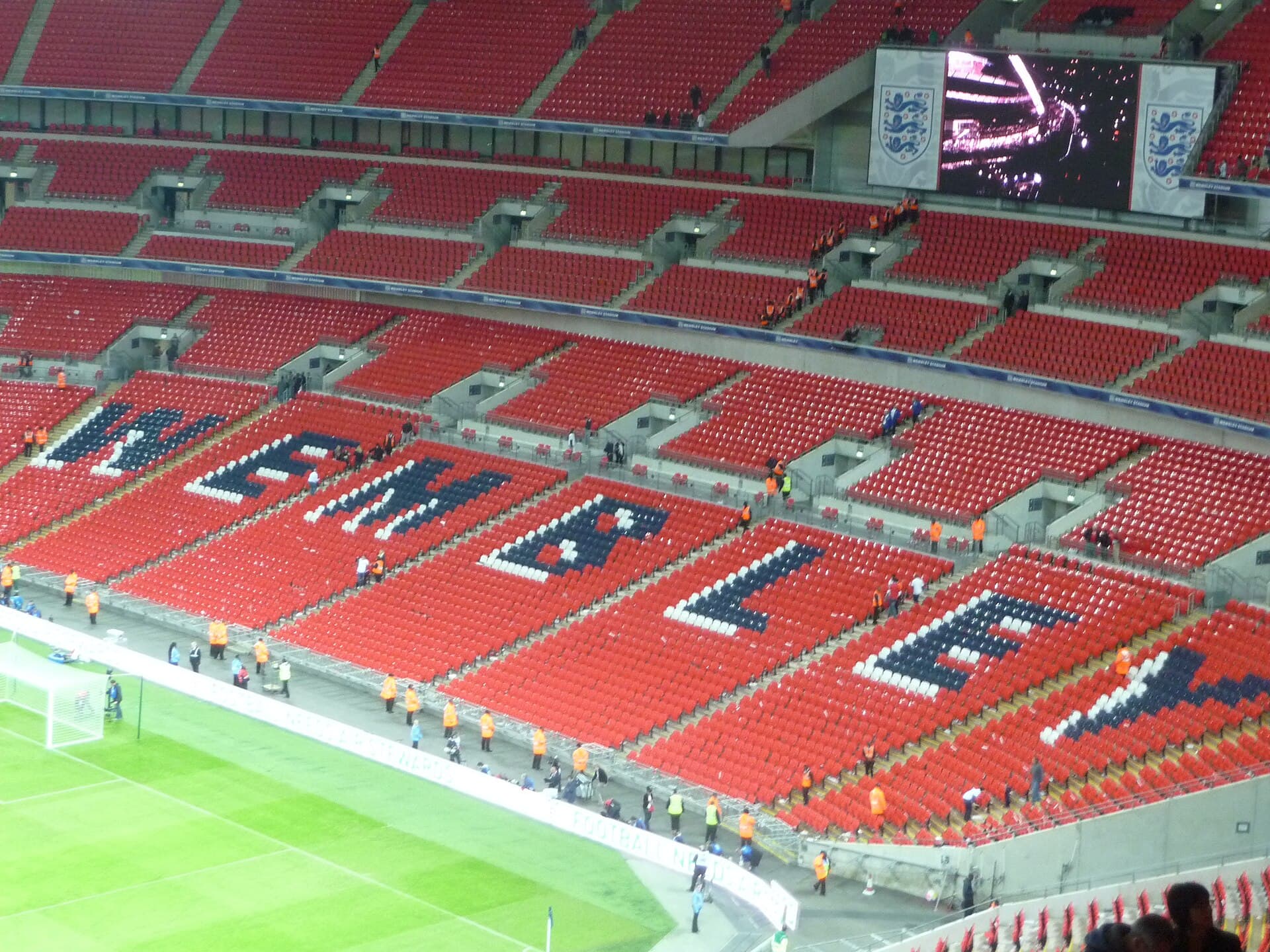 Interiorul stadionului Wembley din Londra, cu tribunele inscripționate „ENGLAND” și terenul de fotbal. (Foto: Lewis Clarke / CC BY-SA 2.0, Wikimedia Commons)