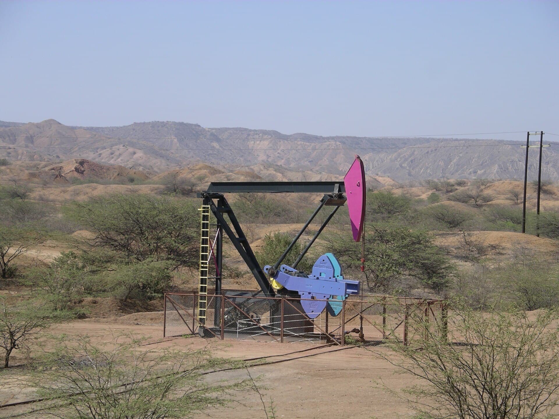 O pompă de extracție a petrolului într-un peisaj arid. (Foto de arhivă: Maurice Chédel / Public domain, Wikimedia Commons)