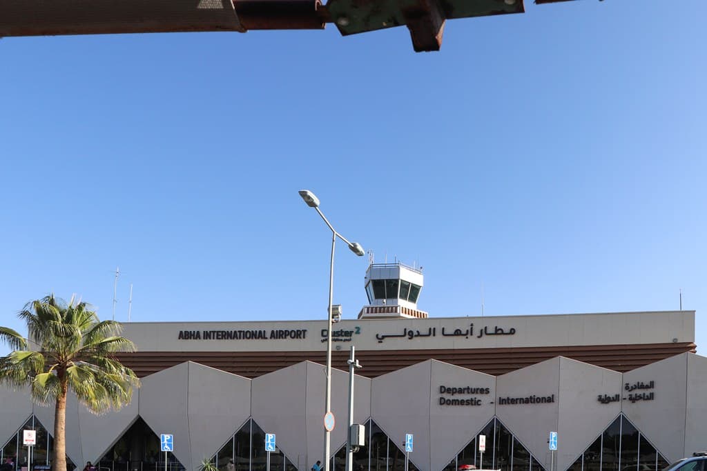 Fațada Aeroportului Internațional Abha din Arabia Saudită, cu indicatoarele pentru plecări interne și internaționale. (Foto: Clemens Schmillen / BY-SA 4.0, Openverse)
