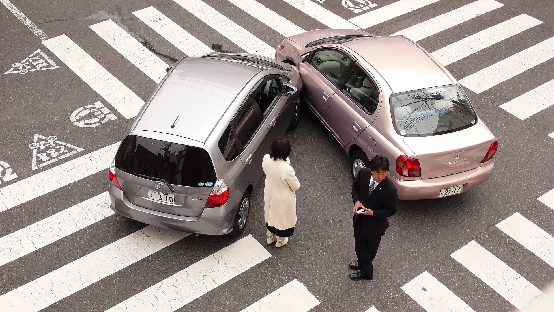 Două autoturisme implicate într-o coliziune într-o intersecție, cu persoane în apropiere. (Foto de arhivă: Shuets Udono / CC BY-SA 2.0, Wikimedia Commons)