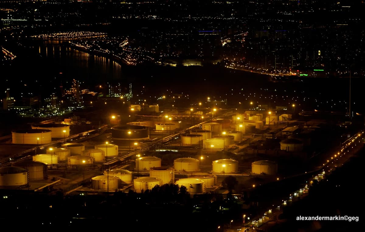 O rafinărie văzută noaptea, cu rezervoare și instalații iluminate. (Foto: Aleksandr Markin / CC BY-SA 2.0, Wikimedia Commons)
