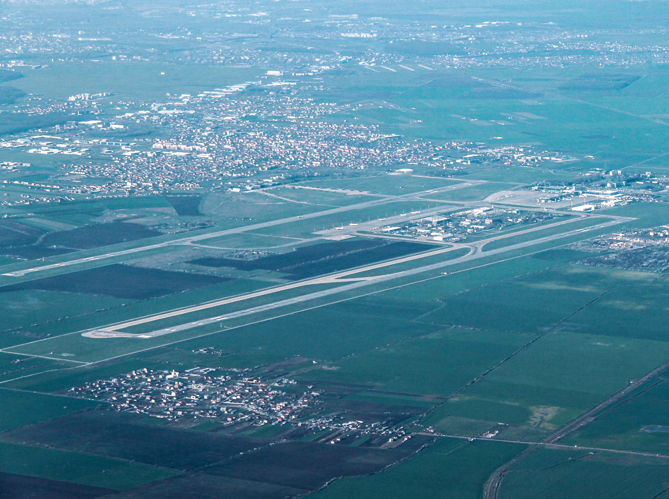 O vedere aeriană a unui aeroport, cu pistele și zonele din jur. (Foto: Cristian Bortes / BY 2.0, Openverse)