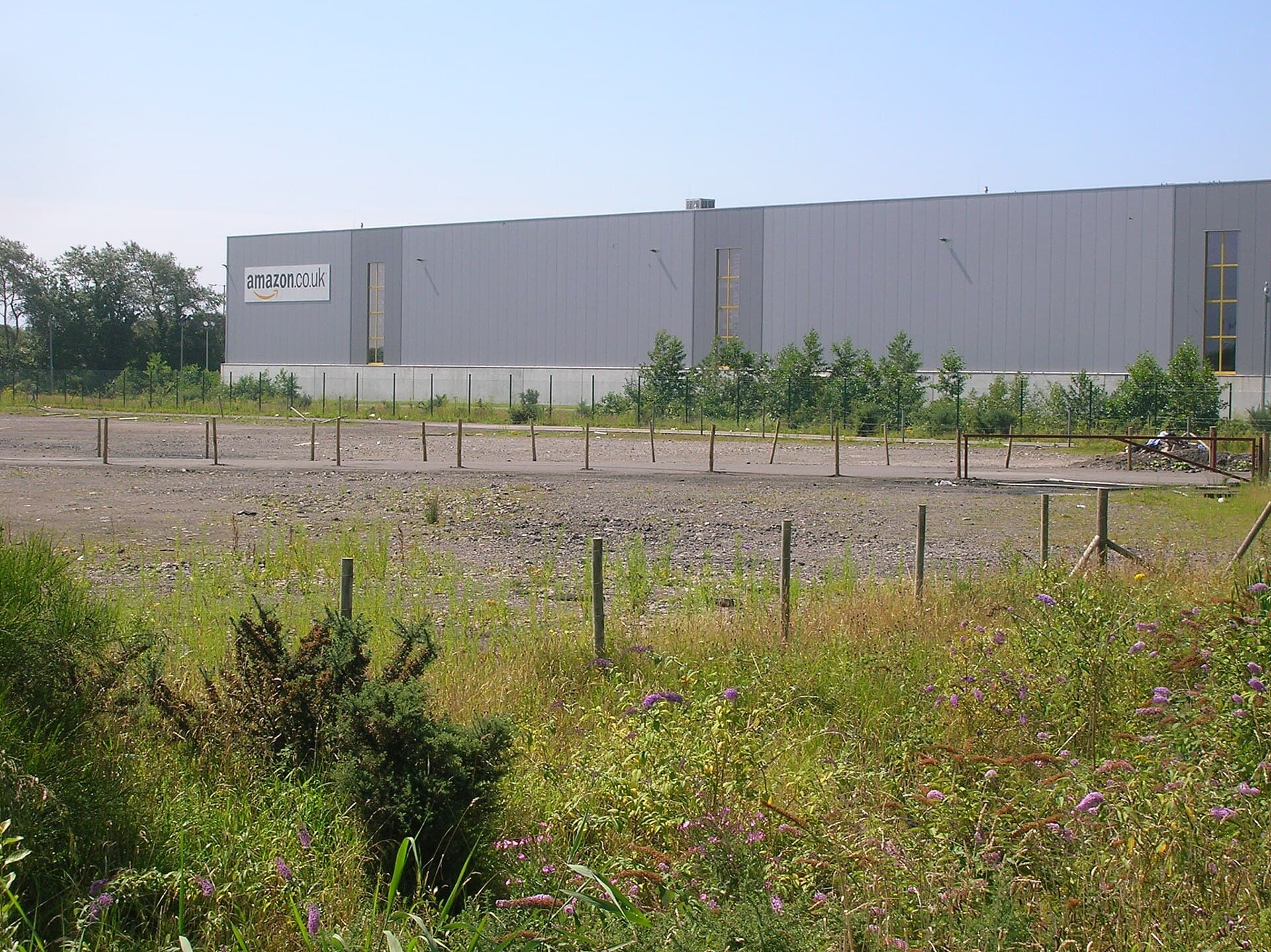 O clădire/centru logistic Amazon, cu sigla Amazon vizibilă pe fațadă. (Foto: Simon Mortimer / CC BY-SA 2.0, Wikimedia Commons)