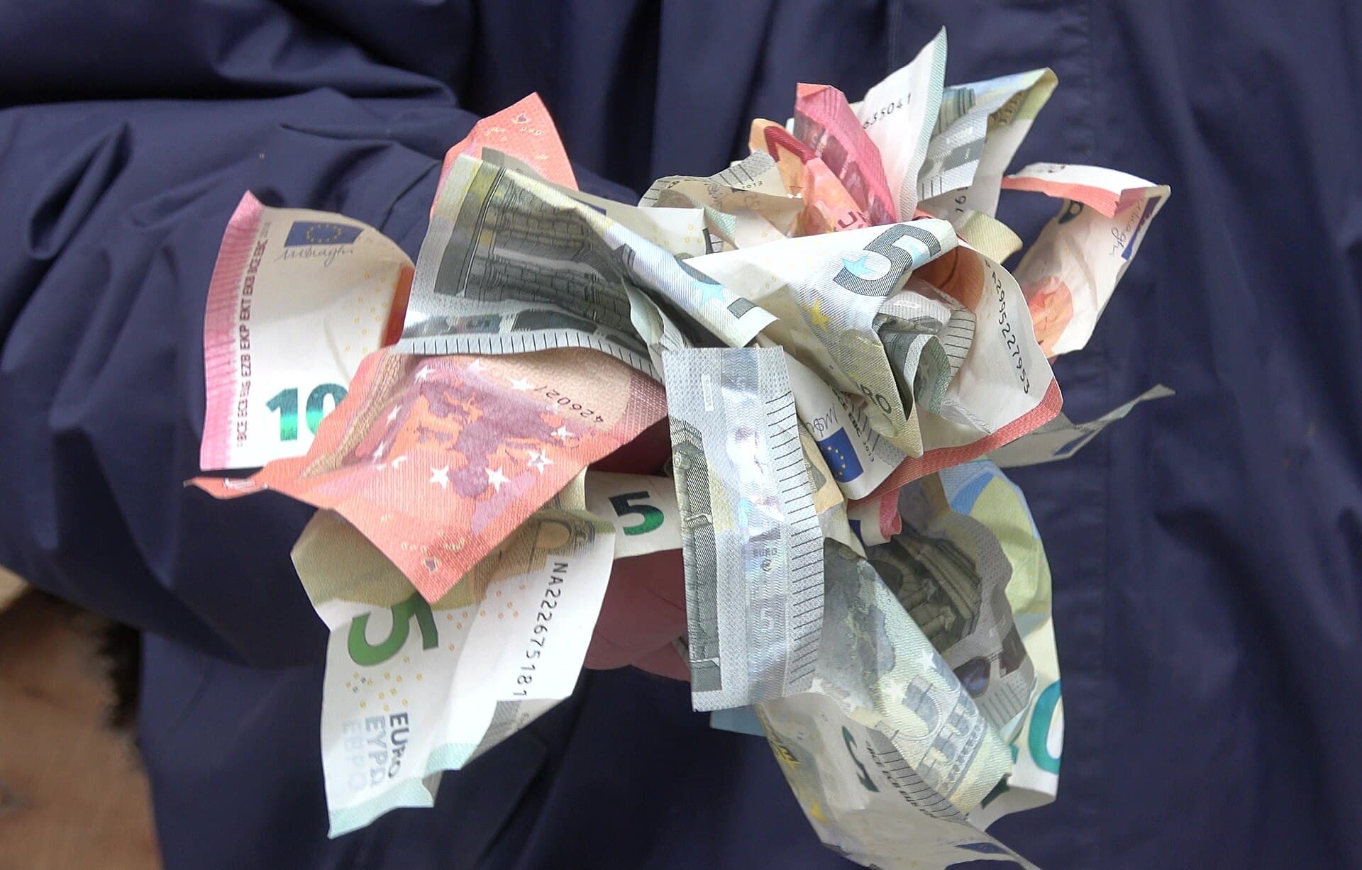 Bancnote euro mototolite și împrăștiate, ținute de o persoană. (Foto de arhivă: Misko3 / CC BY-SA 4.0, Wikimedia Commons)