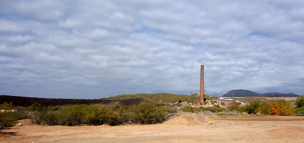 Peisaj industrial cu o fabrică și un coș de fum, văzute de la distanță. (Foto de arhivă: kevin dooley / BY 2.0, Openverse)