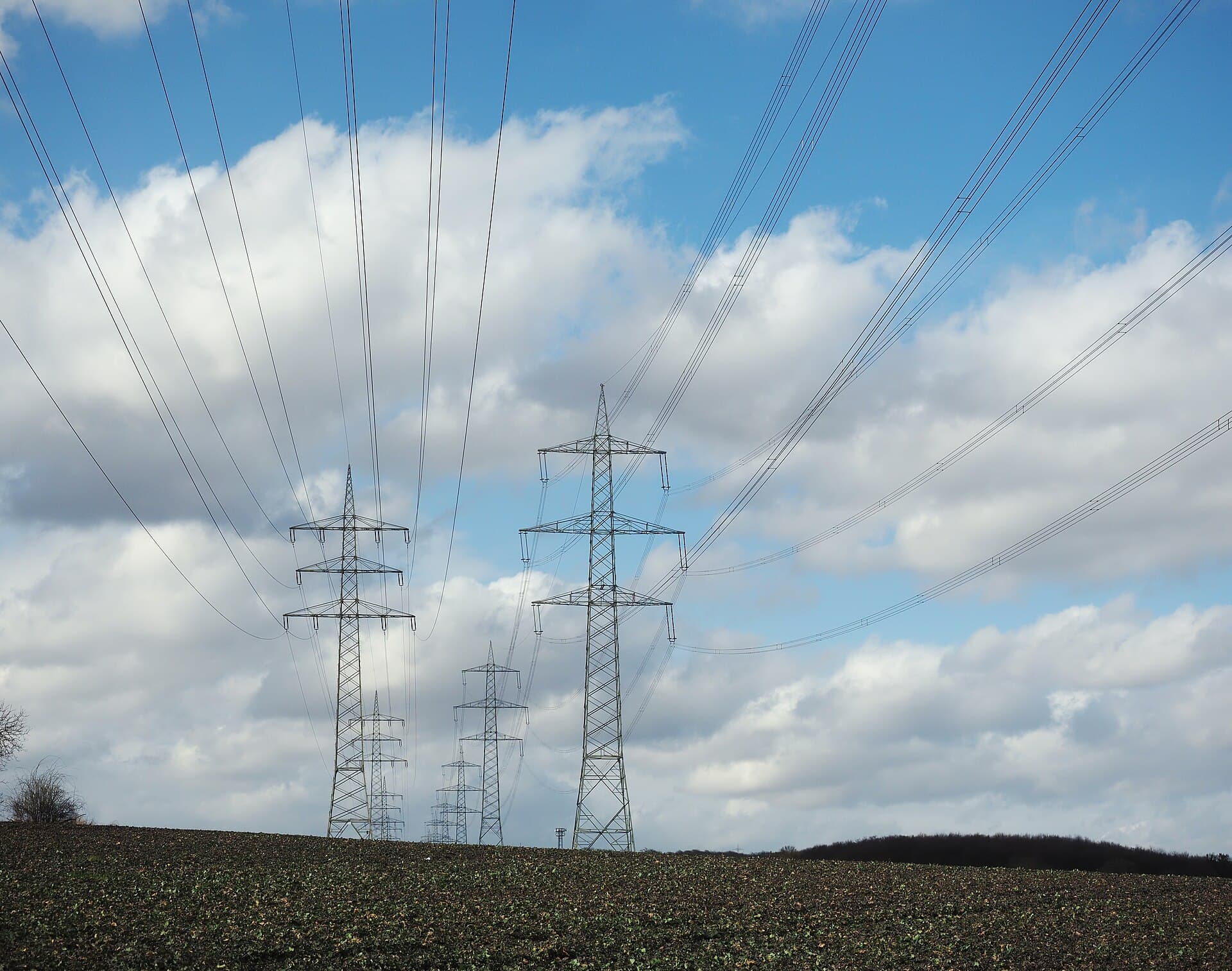 Linii electrice de înaltă tensiune și stâlpi de transport al energiei, într-un peisaj rural. (Foto de arhivă: Kreuzschnabel / CC BY-SA 3.0, Wikimedia Commons)