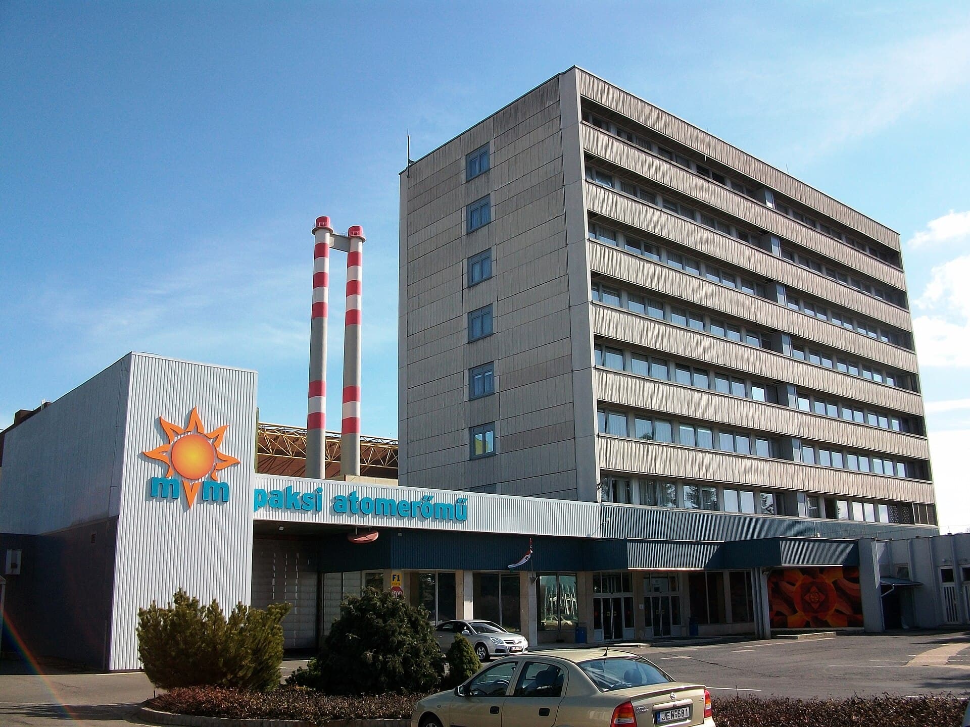 O clădire a centralei nucleare Paks, cu inscripția „paksi atomerőmű” și coșuri de fum în față. (Foto: Barna Rovács (Rovibroni) / CC BY-SA 4.0, Wikimedia Commons)