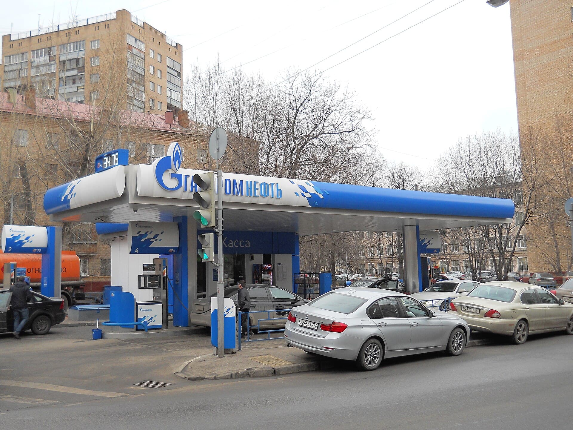 O benzinărie Gazpromneft, cu mașini alimentând și clădiri urbane în fundal. (Foto: Shuvaev / CC BY-SA 4.0, Wikimedia Commons)