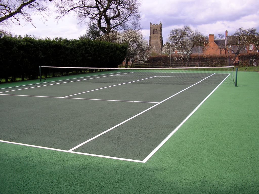 Un teren de tenis în aer liber, fără jucători, într-un parc. (Foto de arhivă: Soft Surfaces Ltd / BY 2.0, Openverse)