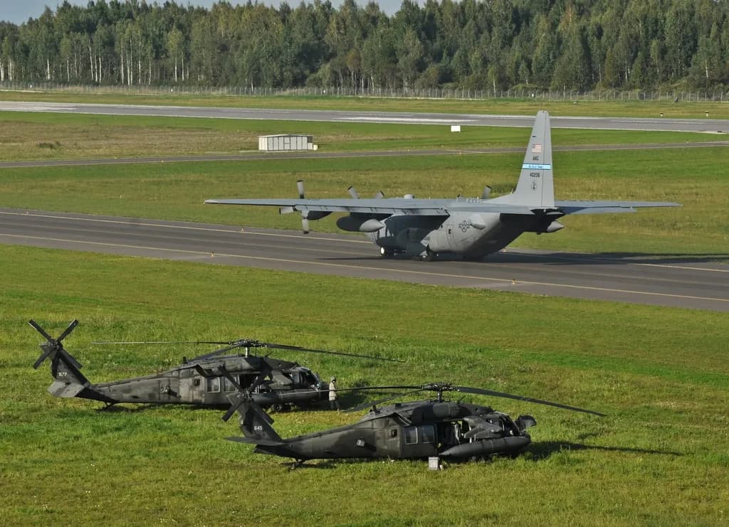 Un aerodrom militar, cu un avion de transport și două elicoptere militare pe pistă și iarbă. (Foto ilustrativă: U.S. Forest Service (source) / CC0 1.0, Openverse)