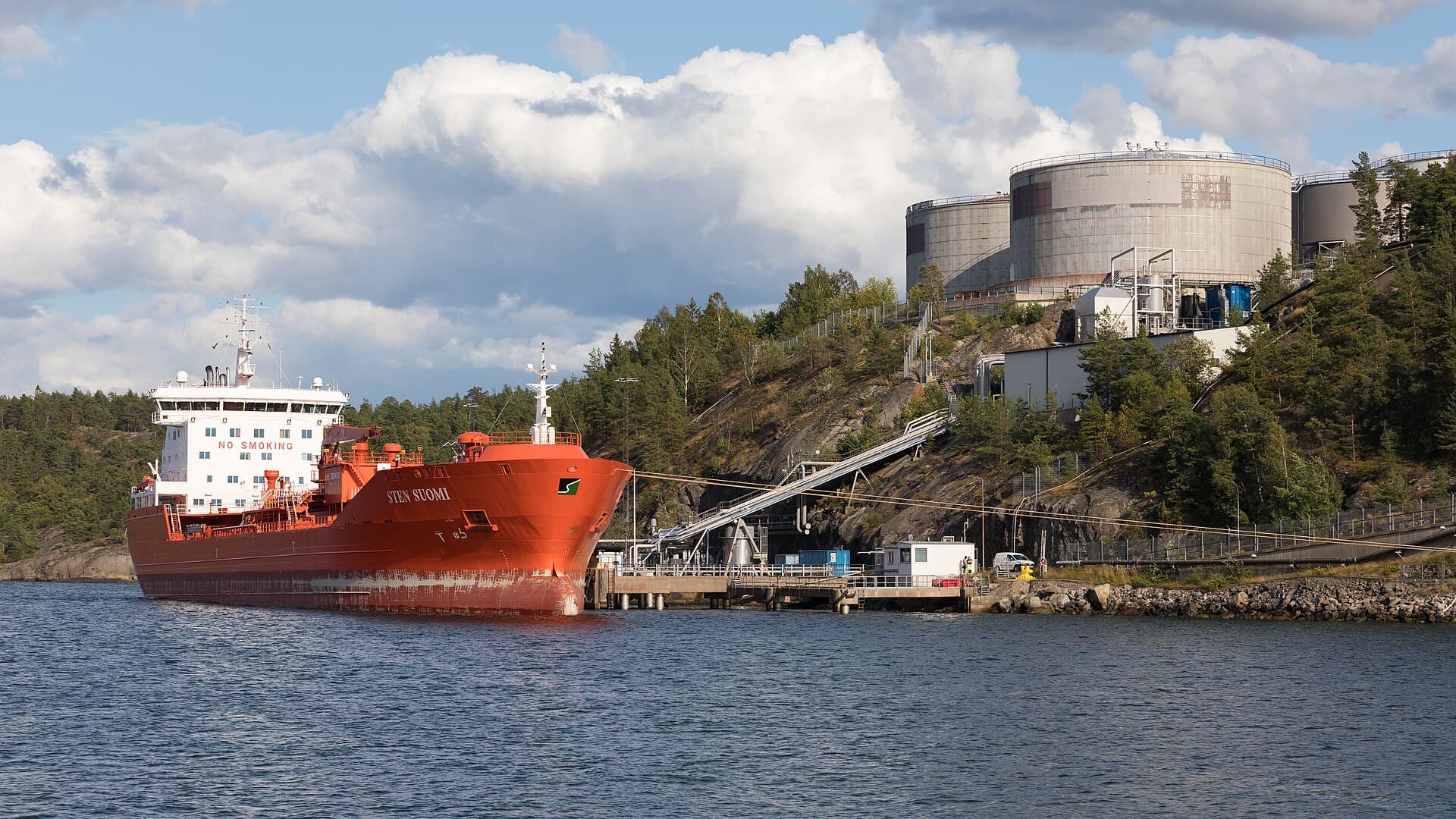 Un petrolier roșu acostat la un terminal de coastă, lângă rezervoare industriale. (Foto de arhivă: Frank Schulenburg / CC BY-SA 4.0, Wikimedia Commons)