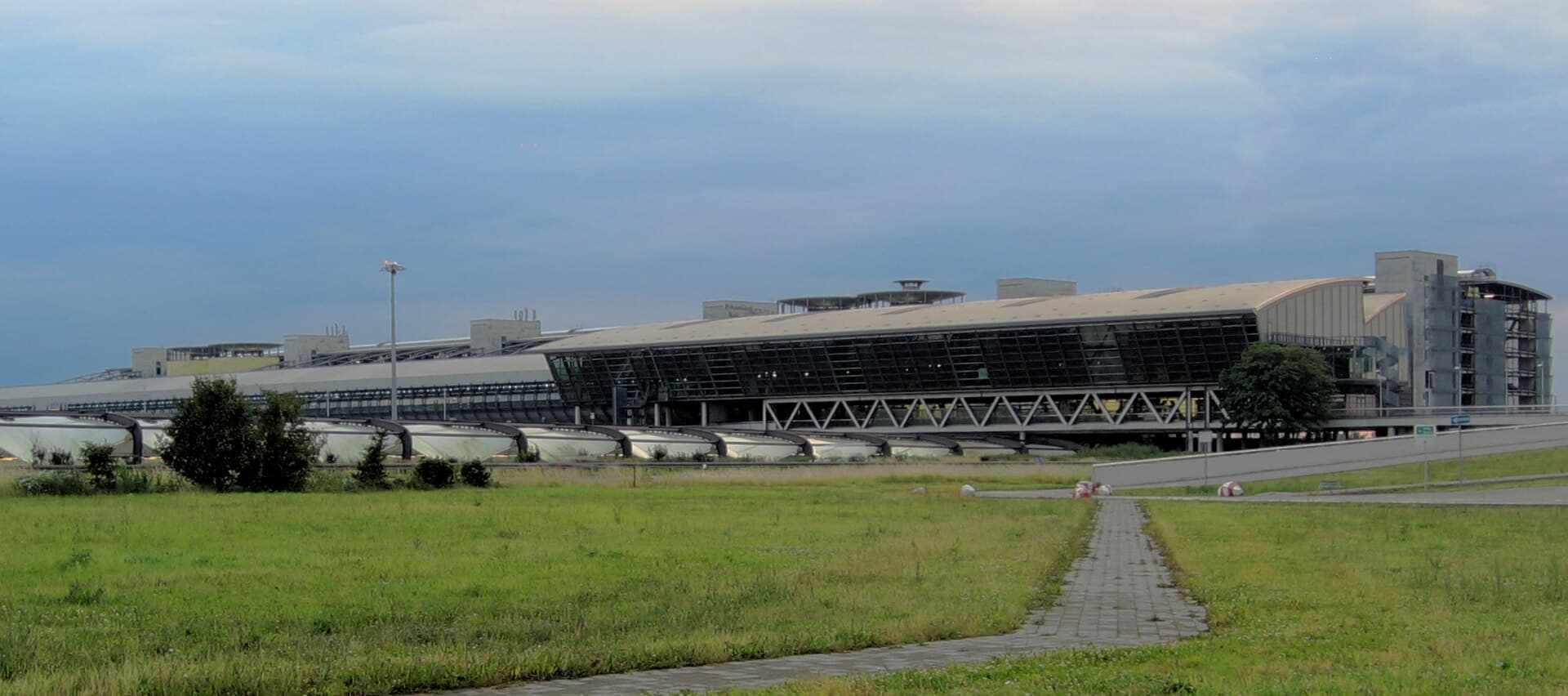 Clădirea terminalului unui aeroport, probabil Aeroportul Leipzig/Halle, văzută din exterior. (Foto: Lumu ( talk ) / CC BY-SA 3.0, Wikimedia Commons)