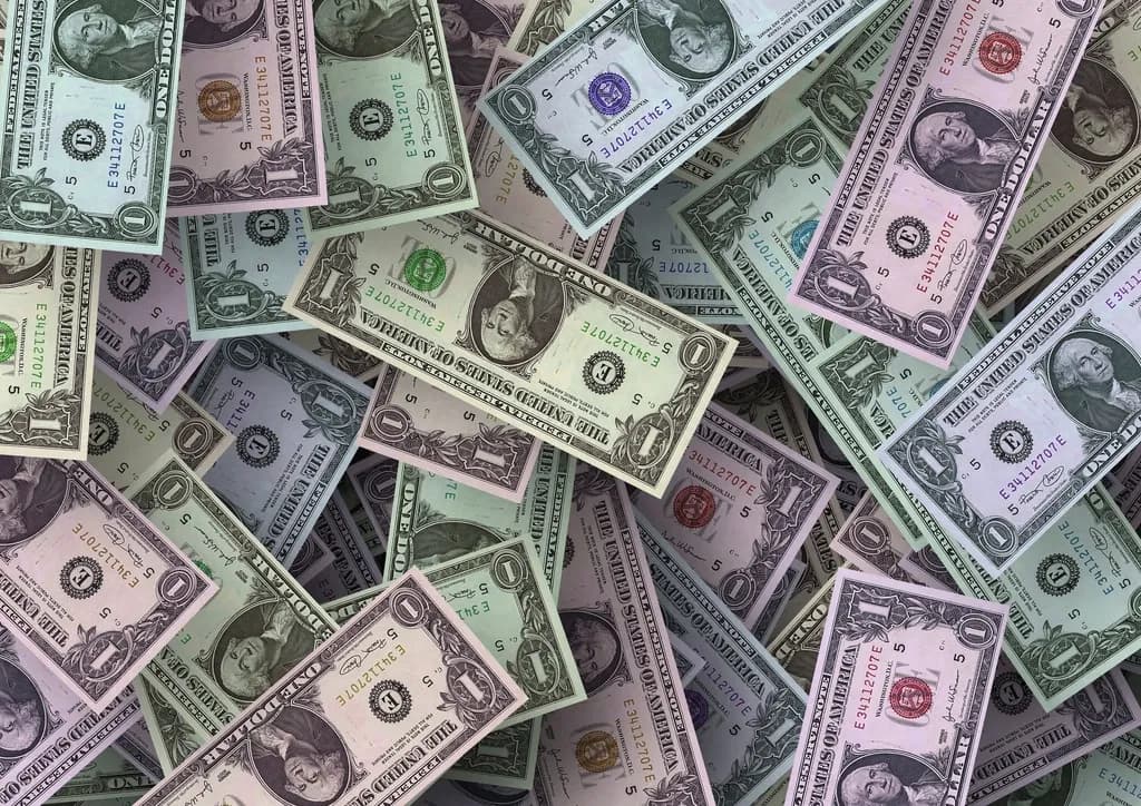 Bancnote americane de un dolar, cu valori diferite de culoare, așezate suprapuse (Foto ilustrativă: necunoscut / CC0 1.0, Openverse)