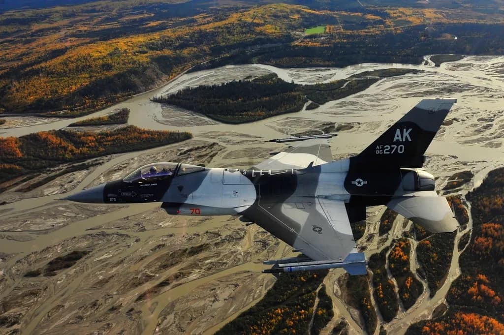 Un avion de vânătoare F-16 american, fotografiat în zbor deasupra unui peisaj montan. (Foto ilustrativă: U.S. Forest Service (source) / CC0 1.0, Openverse)