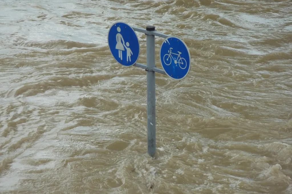 Un indicator pentru pietoni și biciclete, aproape acoperit de ape tulburi de inundație. (Foto ilustrativă: necunoscut / CC0 1.0, Openverse)