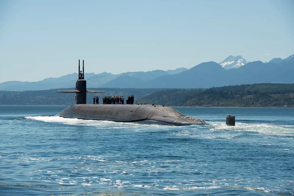 Un submarin militar la suprafața apei, într-un golf, cu munți în fundal. (Foto ilustrativă: U.S. Forest Service (source) / CC0 1.0, Openverse)