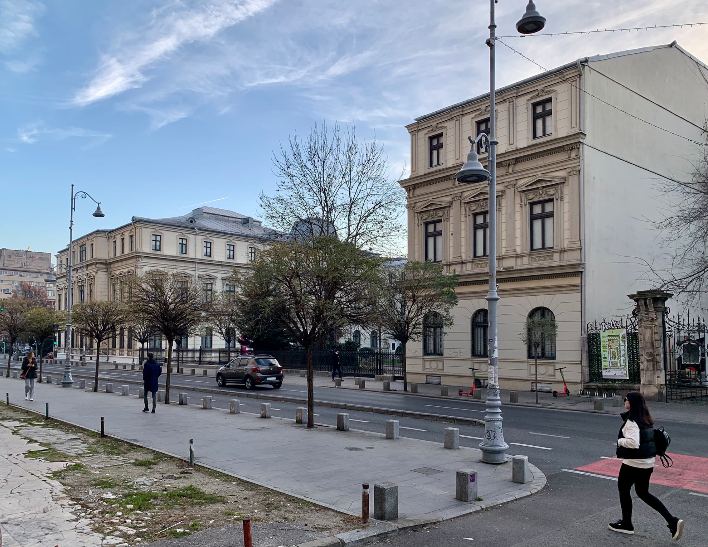 O stradă din centrul Bucureștiului, cu clădiri istorice, traficul rutier și trotuarele de pe Calea Victoriei. (Foto: Neoclassicism Enthusiast / BY-SA 4.0, Openverse)