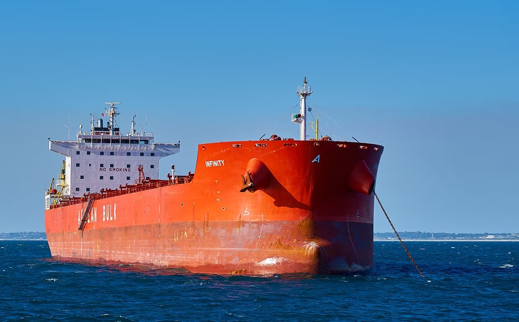 O navă de marfă de mari dimensiuni, de culoare portocalie, fotografiată pe mare. (Foto de arhivă: szeke / BY-SA 2.0, Openverse)