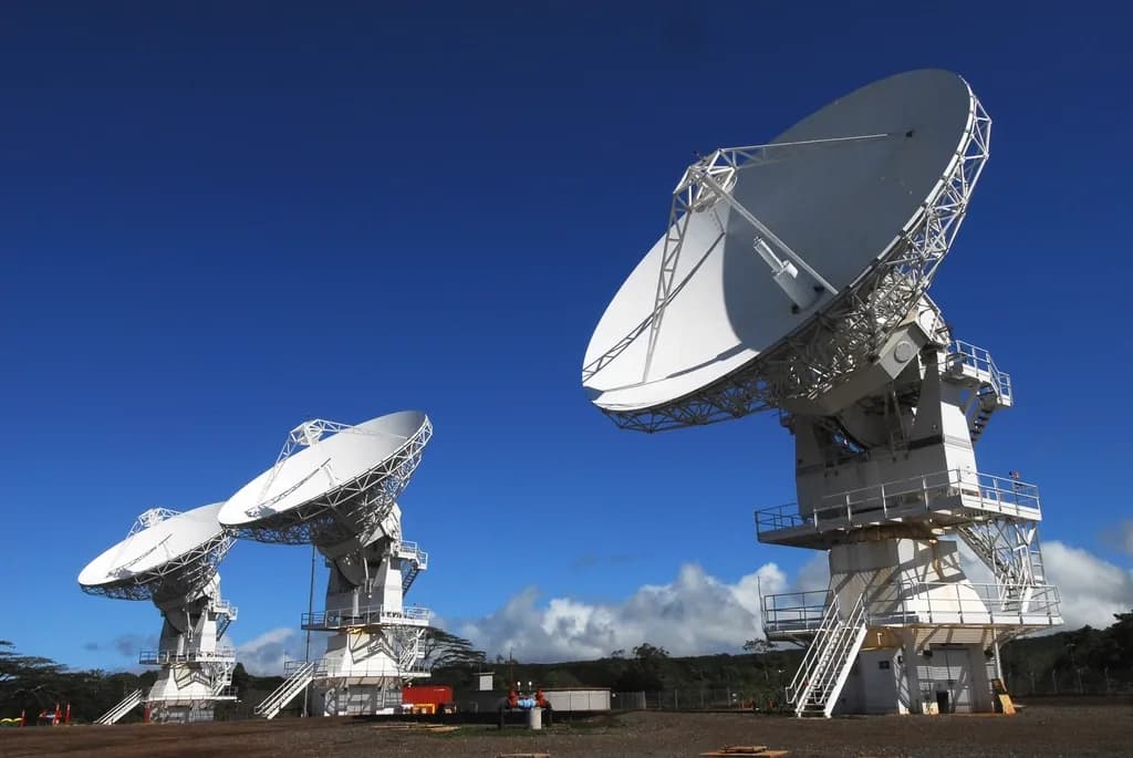 În imagine se văd mai multe antene parabolice mari, de comunicații prin satelit, amplasate în aer liber. (Foto ilustrativă: necunoscut / CC0 1.0, Openverse)
